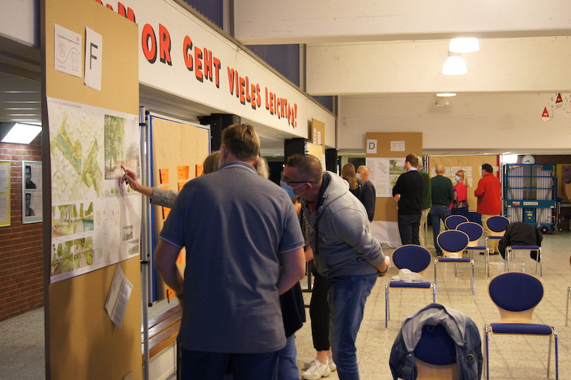 Menschen diskutieren an einer Moderationswand